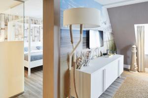 a living room with a floor lamp and a bedroom at Van der Valk hotel Den Haag Wassenaar in Wassenaar