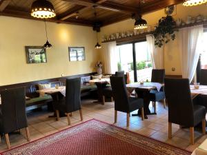 um restaurante com mesas e cadeiras num quarto em Gästehaus Mack em Trittenheim