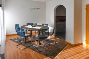 uma sala de jantar com uma mesa e cadeiras azuis em Haus Sonnboden em Andermatt