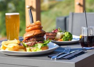 a sandwich and french fries on a table with a glass of beer at Ullswater Heights in Johnby