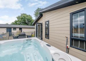 a hot tub in front of a house at Hornbeam Country Park in Honiton