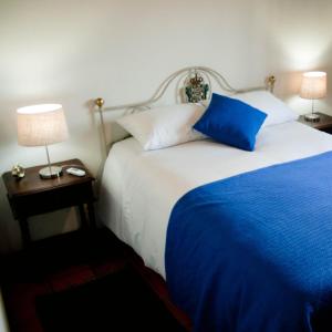 a bedroom with a large bed with blue sheets and pillows at Quinta do Chãozinho in Alijó