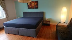 ein Schlafzimmer mit einem blauen Bett und einem Sofa in der Unterkunft Gehoeft Nr. X zu Peccatel in Peckatel