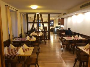 ein Restaurant mit Tischen und Stühlen und eine Person am Tisch in der Unterkunft Gasthaus Adler Allmannsdorf in Konstanz