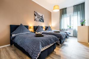 Un dormitorio con dos camas con sábanas azules y blancas. en Comodo Apartments Solingen, en Solingen
