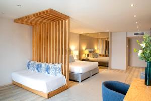 a hotel room with two beds and a mirror at Hotel Cristal Vieira Praia & SPA in Praia da Vieira