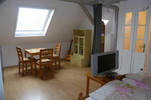 sypialnia ze stołem, telewizorem i łóżkiem w obiekcie Villa Greve - Maisonette Suite w mieście Bad Salzuflen