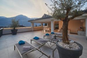 a patio with chairs and a tree on a roof at Penthouse & Garden - luxury apartment in Postal