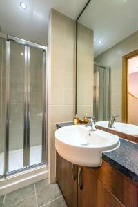 un baño con lavabo y ducha en KM Apartments, en Edimburgo