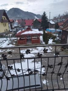 a gate with a gazebo in a town with snow at Dom pod Winogronem in Szczawnica