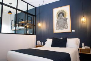 莫雷利亚Romance City Hotel的一间卧室配有一张特大号床和蓝色的墙壁