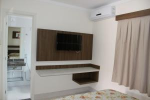 1 dormitorio con TV de pantalla plana en la pared en Lacqua Diroma IV, en Caldas Novas