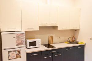 a kitchen with white cabinets and a microwave at Wonderful flat on city center (Mukachivska 4/8) in Uzhhorod