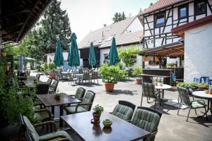 un patio al aire libre con mesas, sillas y sombrillas en Hotel- Landgasthof Baumhof-Tenne en Marktheidenfeld