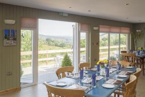 a dining room with a blue table and a balcony at Llanerchindda Farm Guest House in Cynghordy
