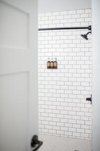 uma casa de banho com um chuveiro de azulejos brancos e 2 WC em SCP Redmond Hotel em Redmond