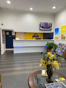 a lobby of a waiting room with flowers on a table at Days Inn & Suites Mobile in Tillmans Corner