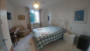 a bedroom with a bed and a chair and a window at La Casa sui Tetti in Genova