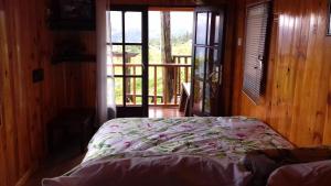1 dormitorio con 1 cama en una habitación con ventana en Ferme Lebon Papillon LA ROULOTTE, en Le Tampon