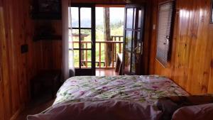 a bedroom with a bed in a room with a window at Ferme Lebon Papillon LA ROULOTTE in Le Tampon