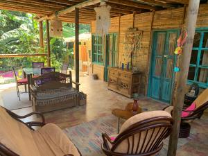 un porche de una casa con sillas y mesa en Jui Chi MaMa en Palomino