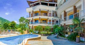 um hotel com piscina em frente a um edifício em Hospedaria Vitória Mar em Ubatuba