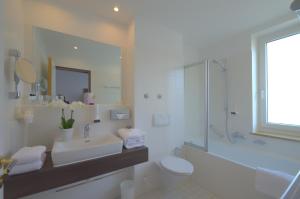 a bathroom with a sink and a toilet and a shower at Lizz Hotel Munich in Munich