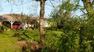 a red car parked in front of a house at Au Bras d'Argent in Berthez +4 photos