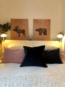 ein Schlafzimmer mit einem Bett mit zwei Gemälden an der Wand in der Unterkunft Cosy centrally located one bedroom flat in Bath