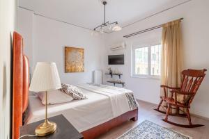 een slaapkamer met een bed met een lamp en een stoel bij Kleio by Heloni Apartments in Athene
