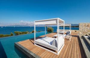 a bed on a wooden deck next to the water at KEROMOUSSI SEASIDE BOUTIQUE HOTEL - Adult only in Meganisi +27 photos