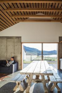 een picknicktafel in een woonkamer met een persoon op een bank bij Drangar Country Guesthouse in Drangar