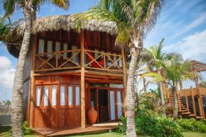 a house with palm trees in front of it at Pousada Jardim do vento in Icaraí