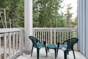 2 Stühle und ein Tisch auf einer Veranda in der Unterkunft Treeline Townhome by Whistler Premier in Whistler