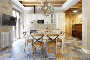 サン・セバスティアンにあるクルザール バスク ステイのキッチン(テーブル、椅子、シャンデリア付)
