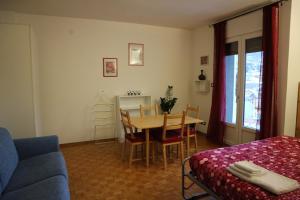 een woonkamer met een tafel en een blauwe bank bij B&B Taramelli in Trento