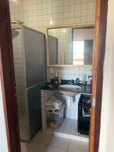 uma casa de banho com um lavatório e um espelho em Casa de praia em Carapibus em Jacumã