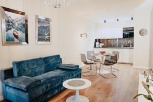 - un salon avec un canapé bleu et une table dans l'établissement Apartament Silence Triventi Szmaragd, à Karpacz
