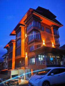 a building with a car parked in front of it at Ludrong Hotel in Thimphu