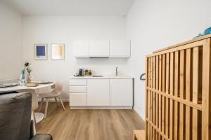 a kitchen with a table and a white kitchen at Emilia Suite Young in Modena