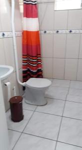 uma casa de banho com um WC e uma cortina de chuveiro em Casa de praia em Passo de Torres
