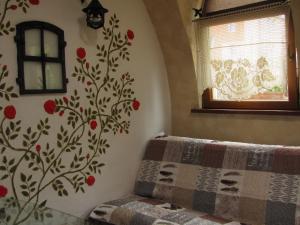 1 dormitorio con 1 cama con flores rojas en la pared en Pokoje Gościnne Skalnik en Kostrzyn nad Odrą