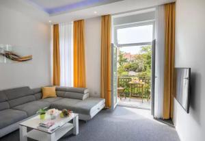 Elenas Rooms & Apartment في زغرب: غرفة معيشة مع أريكة وطاولة ونافذة