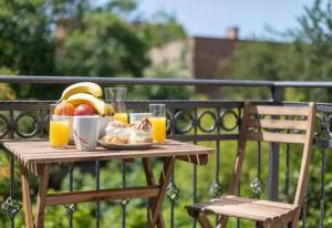 einem Holztisch mit einem Obstteller und Orangensaft in der Unterkunft Elenas Rooms & Apartment in Zagreb