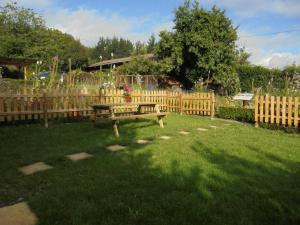 a wooden fence with a bench in a yard at Albergue Areitz Soroa in Arce