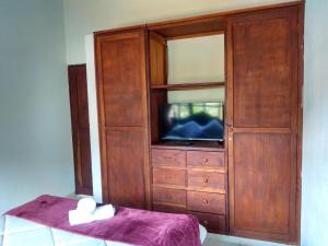 un gran armario de madera con TV. en Hospedaje Casa Marsella, en Villa de Leyva