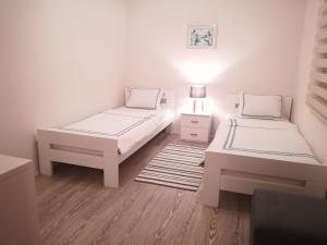 a white room with two beds and a lamp at SkyLine apartments in Mostar +49 photos