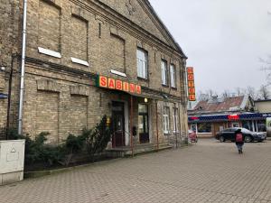 a brick building with a sign on the side of it at Hotel Sabina in Riga