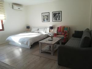 ein Schlafzimmer mit einem Bett, einer Couch und einem Tisch in der Unterkunft SkyLine apartments in Mostar + 52 Fotos