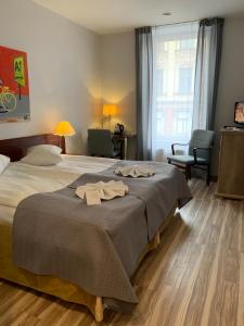 a bedroom with a bed with two towels on it at A1 Hotel Riga City Center in Rīga